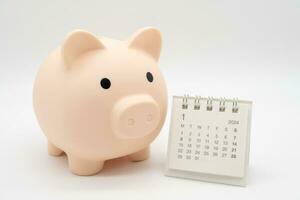 Piggy Bank and Desk calendar isolated on white background. For retirement, Pension Plan concept. Time for a new start. photo