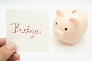 BUDGET text on paper with Piggy bank on a white background. Finance, saving money concept. photo