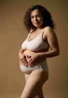 madre con visible cuerpo marcas, haciendo corazón forma terminado su postnatal barriga con posparto defectos, aislado antecedentes foto