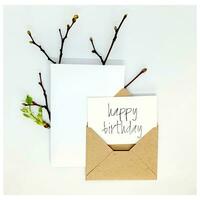 Happy birthdat card. handmade invitation lists, craft envelope, on white background. Overhead view. Flat lay, top view. photo