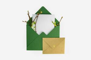 Mockup invitation, blank greeting card with spring greens. Flat lay, top view. photo