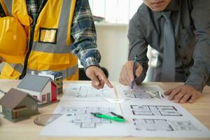 Construction engineers discuss and exchange ideas with architects to improve house plans to meet customer needs. A concept for exchange of design ideas between construction engineers and architects. photo