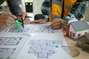Construction engineers discuss and exchange ideas with architects to improve house plans to meet customer needs. A concept for exchange of design ideas between construction engineers and architects. photo