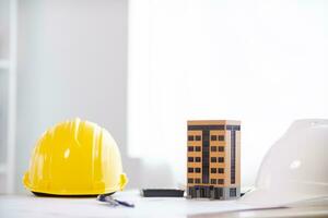 Yellow safety helmet were prepared for workers to wear before entering the construction area to prevent the danger of falling objects from working. Yellow safety helmet is placed on a wooden table. photo