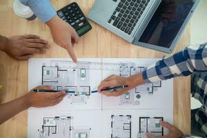 construcción ingenieros discutir y intercambiar ideas con arquitectos a mejorar casa planes a reunirse cliente necesidades. un concepto para intercambiar de diseño ideas Entre construcción ingenieros y arquitectos foto