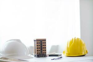 Yellow safety helmet were prepared for workers to wear before entering the construction area to prevent the danger of falling objects from working. Yellow safety helmet is placed on a wooden table. photo