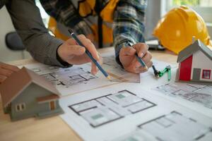 Construction engineers discuss and exchange ideas with architects to improve house plans to meet customer needs. A concept for exchange of design ideas between construction engineers and architects. photo