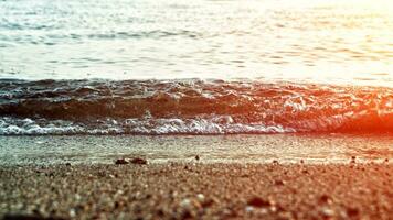 Waves crashing on the beach at sunrise photo