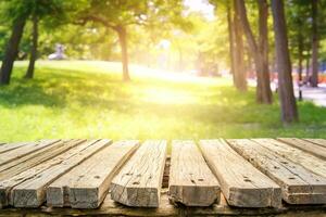 Empty wooden floor for display, advertise, and promote montage product with forest background, and sunlight. photo