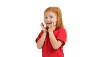 agradable linda optimista pequeño niña participación su manos cerca cara y sonriente mientras expresando alegría. foto