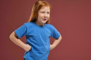 Portrait of cute redhead emotional little girl on red background photo
