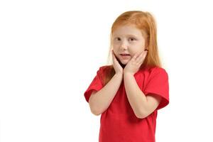 Pleasant cute upbeat little girl holding her hands near face and smiling while expressing joy. photo