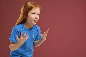 Portrait of cute redhead emotional little girl on red background photo