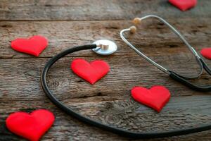 Stethoscope and hearts on a wooden foen. Valentine day concept photo