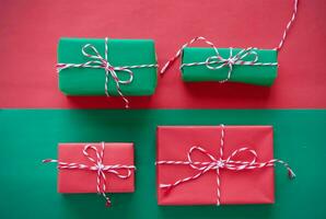 Christmas gift box composition on a red and green background. Flat lay top view copy space photo