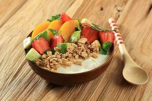A Bowl of Homemade Granola, Yogurt, Fresh Berries on Wood Table. photo