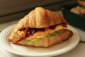 Croissant Sandwich with Cheese, Egg, Ham, Tomato and Lettuce photo