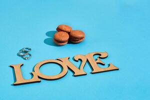 Macaroons on a blue background with the words I love spelt out i photo