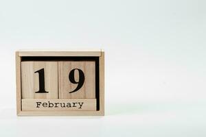 Wooden calendar February 19 on a white background photo