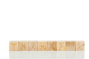 Wooden cubes with letters thankful on a white background photo