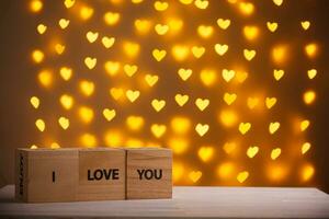 wooden cubes I Love You on a blurred background of hearts photo