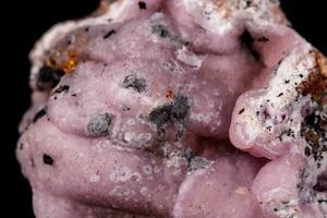 Macro pink Smithsonite mineral stone on microcline on black background photo