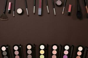 Top view on set of cosmetics for professional make-up on brown background photo