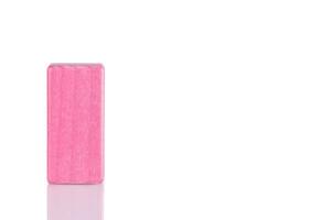 Wooden cube of pink color on a white background photo