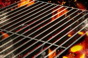 Hot empty portable summer barbecue BBQ grill with bright flaming fire and ember charcoal. Cookout concept. Close up photo