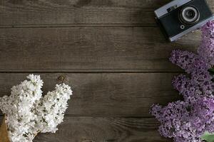 Lilac blossom on rustic wooden background with empty space for greeting message. Top view photo
