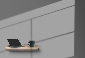 There are a tablet and a cup standing on a wooden shelf, suspended from the gray wall, shadows from the window on it. Mockup. Close-up. photo