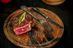 Grill juicy beef steak with salt pepper and rosemary. photo