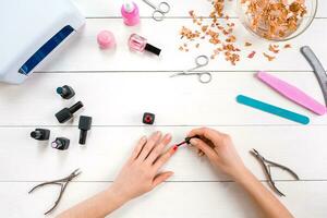 Paint your own nails. Manicure set and nail polish on wooden background photo