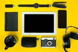 Black objects from the office on a yellow background. Work and creativity. Top view. photo