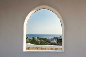 Egypt. A look through the frame on the palm trees. Beautiful view. White house and veranda overlooking the sea and palm trees. photo