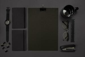 Black objects from the office on a dark gray background. Work and creativity. Top view. photo