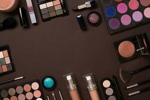 Top view on set of cosmetics for professional make-up on brown background photo