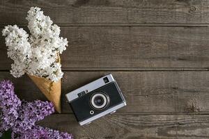 Lilac blossom on rustic wooden background with empty space for greeting message. Top view photo