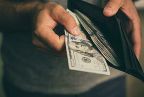 Man looks in the wallet. Cash. Wealthy man counting his money. Close up. photo