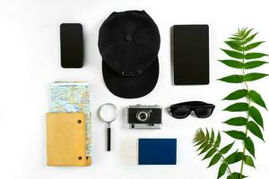 Travel accessories set on white background smart, passport, cap, notepad, map, camera and sunglasses. Top view point. photo