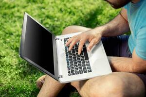 Top view male hands using notebook outdoors in urban setting while typing on keyboard, businessman freelancer working on computer. photo