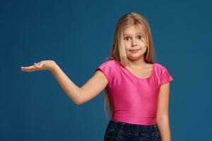 Portrait of adorable emotional little girl on blue background photo