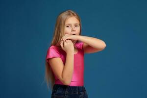 retrato de adorable emocional pequeño niña en azul antecedentes foto