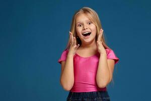 Portrait of adorable emotional little girl on blue background photo