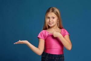 retrato de adorable emocional pequeño niña en azul antecedentes foto