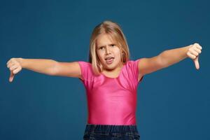 Portrait of emotional expressive little girl on blue background photo