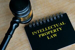 Top view of black notebook with text Intellectual Property Law and with gavel background photo
