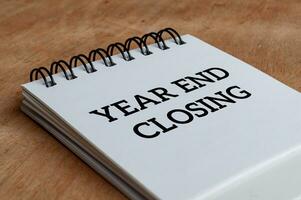 Year end closing text on white notepad. Year end closing concept photo