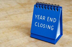 Year end closing text on blue notepad with customizable space for text. Closing concept. photo