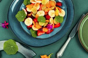 Tasty fruit salad with edible nasturtium. photo